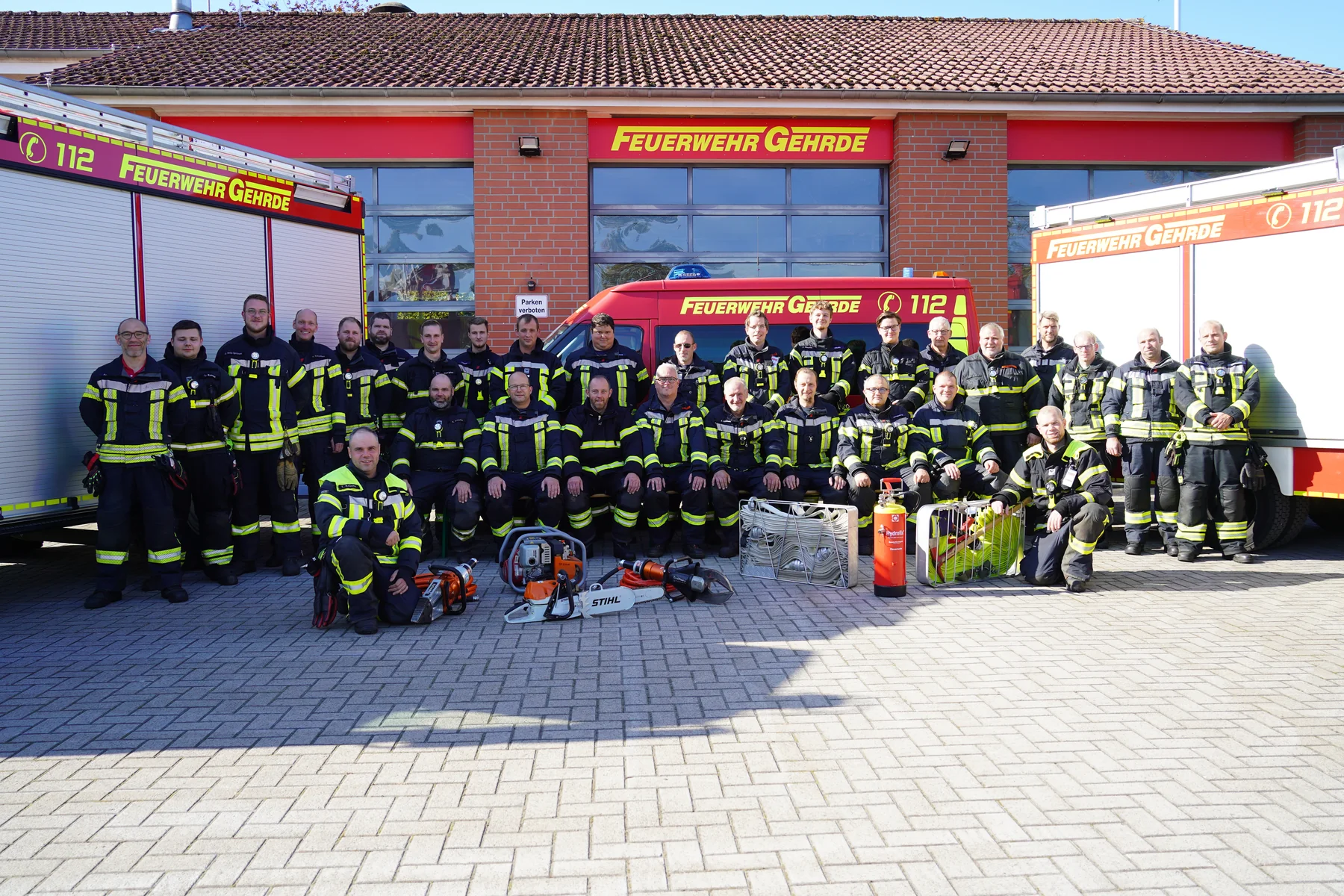 Die gesamte Mannschaft der Feuerwehr Gehrde mit ihren Fahrzeugen vor dem Gerätehaus